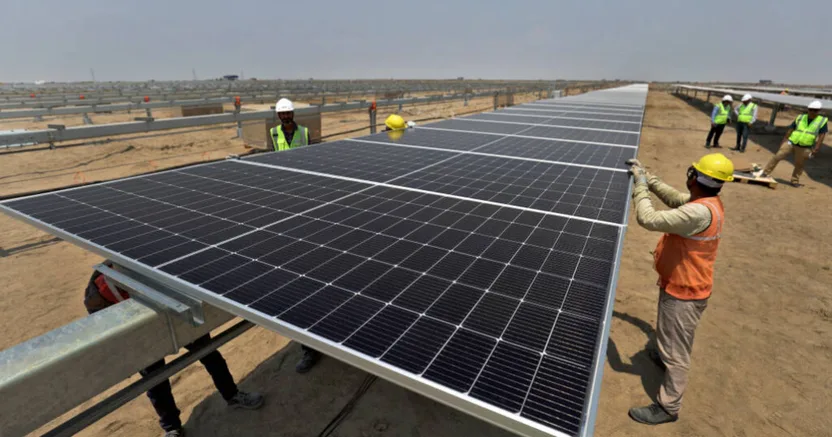 Trabalhadores instalando painéis solares em usina fotovoltaica